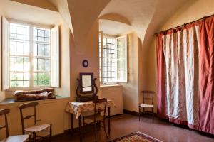 Habitación con mesa, sillas y ventanas. en Castello di Rocca Grimalda, en Rocca Grimalda
