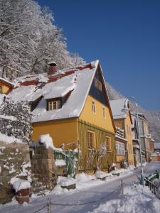 Una casa amarilla con nieve encima. en Ferien im Denkmal an der Elbe, en Stadt Wehlen