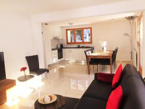 ein Wohnzimmer mit einem schwarzen Sofa und einem Tisch in der Unterkunft Apartments Soldanella in Leukerbad