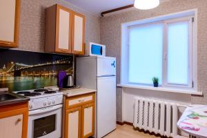 une cuisine avec un réfrigérateur blanc et une fenêtre dans l'établissement Apartment TwoPillows on Lomonosova 9, à Vorkuta