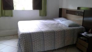 a bedroom with a bed with a blanket on it at Casa em Arraial d'Ajuda in Arraial d'Ajuda