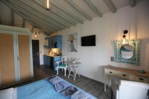 1 dormitorio con 1 cama y cocina con mesa en Skiathos Argento, en Kolios