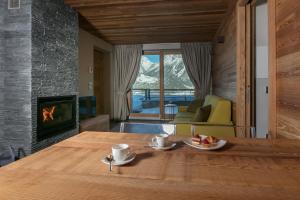 ein Esszimmer mit einem Tisch und einem Kamin in der Unterkunft Chalet Heidi in Bormio