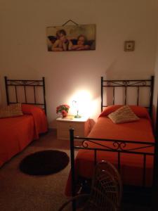 ルッファーノにあるCasa Vacanza Salento con PISCINA e BARBECUEのベッドルーム1室(ベッド2台、ランプ付きテーブル付)
