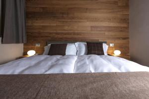 a bedroom with a bed with a wooden wall at Chalet Heidi in Bormio