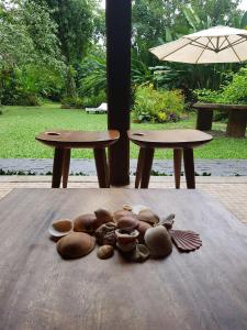 um monte de cogumelos sentados numa mesa com dois bancos em Casa pé na areia - Praia do Felix em Ubatuba