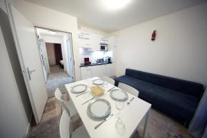 كوزي استوديو (102) كلوز تو كورنافين ترين ستيشين في جنيف: غرفة معيشة مع طاولة بيضاء وأريكة زرقاء