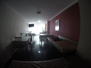 ein dunkles Zimmer mit einem Tisch und Stühlen sowie einem Esszimmer in der Unterkunft Hotel Villa del Mar in Panama-Stadt