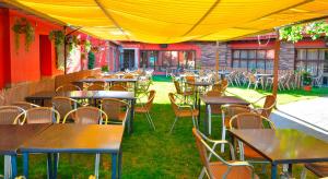 een rij tafels en stoelen onder een gele tent bij Cuatro Caminos in Piedrabuena