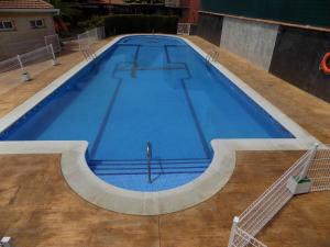 a large blue swimming pool with a wooden floor at Cuatro Caminos in Piedrabuena