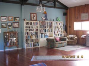 a living room with book shelves filled with books at Woolshed Bed & Breakfast in Takaka