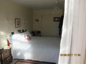 a bedroom with a white bed with a pillow at Woolshed Bed & Breakfast in Takaka