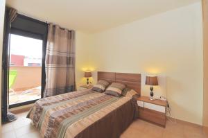 - une chambre avec un lit et une grande fenêtre dans l'établissement Apartment Arigata, à Lloret de Mar