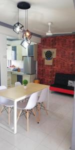 uma sala de estar com uma mesa e cadeiras e um sofá em DT Homestay floor level 4 em Malaca