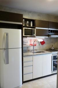 una cucina con frigorifero bianco e lavandino di Departamento Drury a San Martín de los Andes