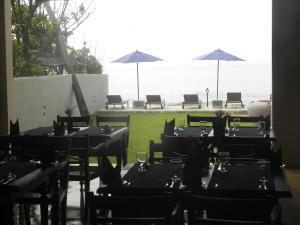 a restaurant with tables and chairs and a view of the ocean at Amanda Beach Villas in Unawatuna
