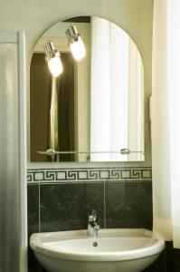 y baño con lavabo y espejo. en Hotel La Campagnola 1926, en Zevio