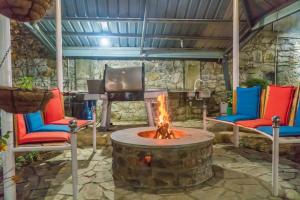 a fireplace in a room with two chairs and a tv at Tea Hills Bungalow in Hatton