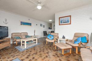 a living room with couches and a tv at Sun & Surf Aldinga Beach Apartment in Aldinga Beach