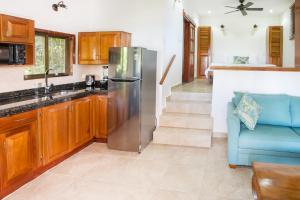 a kitchen with a stainless steel refrigerator and a blue couch at Hotel Villas Nicolas - Adults Only in Manuel Antonio