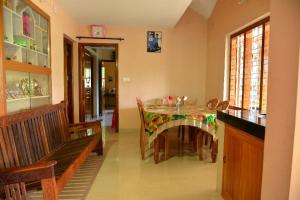 a dining room with a table and a bench at Nandanam Villa in Kaniyāmbetta