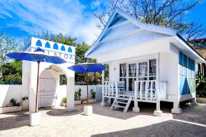 una pequeña casa con dos sombrillas azules delante en Balatoa, en Bira