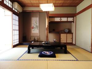 una stanza con tavolo al centro di una stanza di EN Guest house a Matsumoto