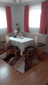 a table and two chairs with a white table and two windows at Temelerhof in Gries im Sellrain