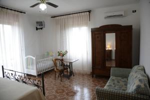 カパッチョ・ペストゥムにあるB&B La Porta Del Cilentoのリビングルーム(ベビーベッド付)、ベッドルーム1室が備わります。