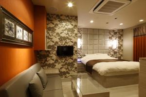 a bedroom with a bed and a flat screen tv at Hotel Waltz Okazaki (Adult Only) in Okazaki