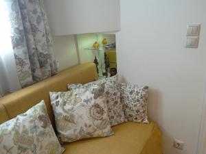 un divano con cuscini in una stanza di Be My Guest Apartment ad Atene