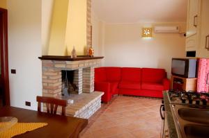 sala de estar con sofá rojo y chimenea en villa pascoli, en Domus de Maria