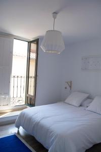 Un dormitorio blanco con una cama grande y una ventana en VIVIENDA DE USO TURÍSTICO CASA ABAD, en Ávila