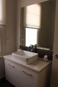 La salle de bains est pourvue d'un lavabo blanc et d'un miroir. dans l'établissement Abbey View, à Bendigo