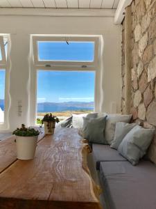 a living room with a couch and a large window at Milo Milo Suites in Mandrakia