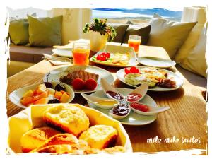 uma mesa de madeira com pratos de comida em Milo Milo Suites em Mandrakia