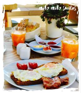 a breakfast of eggs and bacon on a table at Milo Milo Suites in Mandrakia