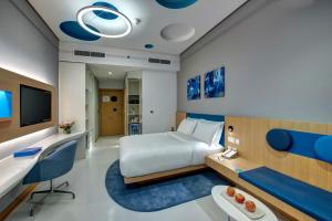 ドバイにあるアル クーリー イン バール ドバイのベッドとデスクが備わるホテルルームです。