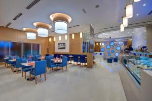 a dining room with blue chairs and tables in a restaurant at Al Khoory Inn Bur Dubai in Dubai