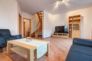 a living room with a table and a tv at Ferienhaus "Seestern" in Ostseebad Karlshagen