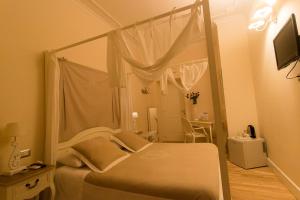 1 dormitorio con cama blanca con dosel y espejo en Trastevere Belvedere B&B, en Roma