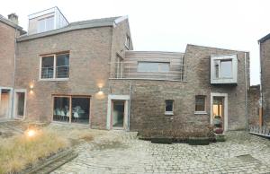 - un grand bâtiment en briques avec une terrasse en face dans l'établissement LaGrange-Chambres d'hôtes, à Liège