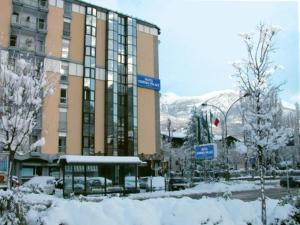 a large building with snow in front of it at Hotel Norden Palace in Aosta