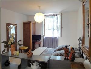 a bedroom with a bed and a table and a window at Gite La Gourmandine in Saint-Andiol