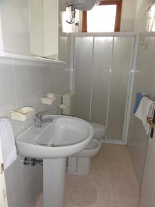 ビビオーネにあるDiana - Appartamentiの白いバスルーム(洗面台、トイレ付)