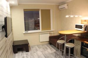 een kleine keuken met een tafel en een raam bij Апартаменты в центре OrenRoom56 in Orenburg