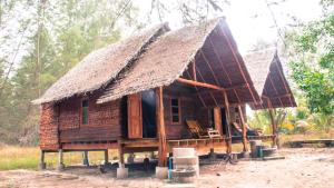una pequeña casa de madera con techo de paja en Rakkan Resort en Ko Phra Thong
