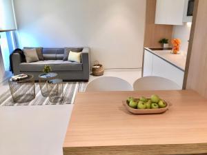 a living room with a table with a bowl of apples at Inside Bilbao Apartments in Bilbao