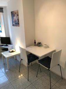 a white desk with two chairs and a computer at Apartment de Boer in Zandvoort