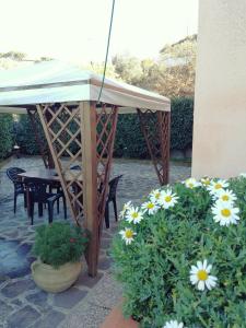 einen Pavillon mit einem Tisch, Stühlen und Blumen in der Unterkunft casa di amici in Campagnano di Roma